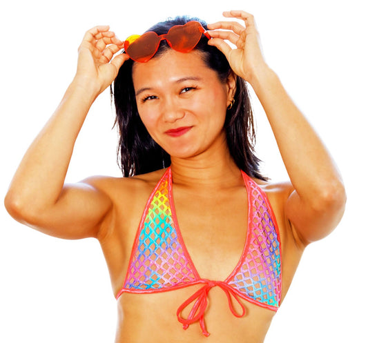 Woman wearing a colorful bikini with sunglasses on a white background