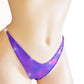 Irridescent purple thong with color changing rhinestones.