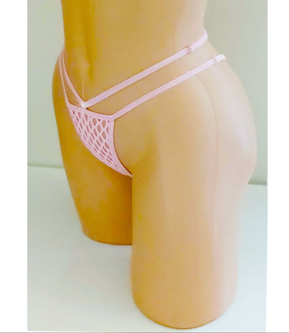 A pink fishnet g-string adjustable strap thong displayed on a tan mannequin torso against a plain light background. The set includes a halter-style triangle top with a front tie and matching strappy low-rise bottoms in fishnet. displayed on a tan mannequin torso against a plain light background. The bikini features a triangle top with side ties and matching strappy bottoms.