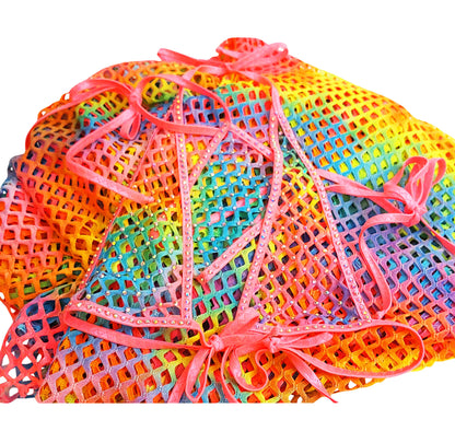 Pile of rainbow fishnet fabric with a Rainbow fishnet halter bikini  that sparkles lying on top.