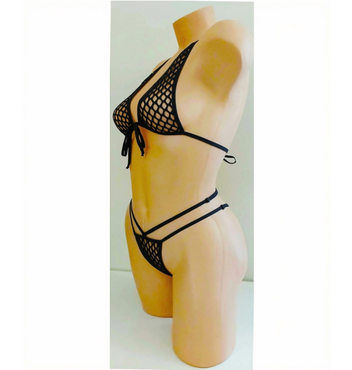 Black fishnet string bikini set displayed on a beige female mannequin torso against a plain light background.
