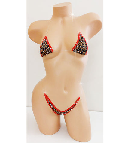 A two-piece bikini set displayed on a beige female mannequin torso. The bikini features a black leopard print pattern with red trim and red side straps, set against a plain white background.