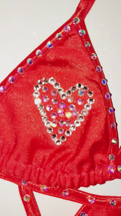 Video of a red bikini with rhinestone hearts on it.