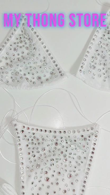 Video of Product of White mesh invisible strap string bikini thong covered in diamond rhinestones on a white background as well as displayed on a mannequin.