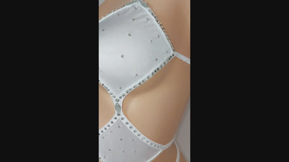 Video of a strappy white one piece with cut outs and covered in rhinestones.